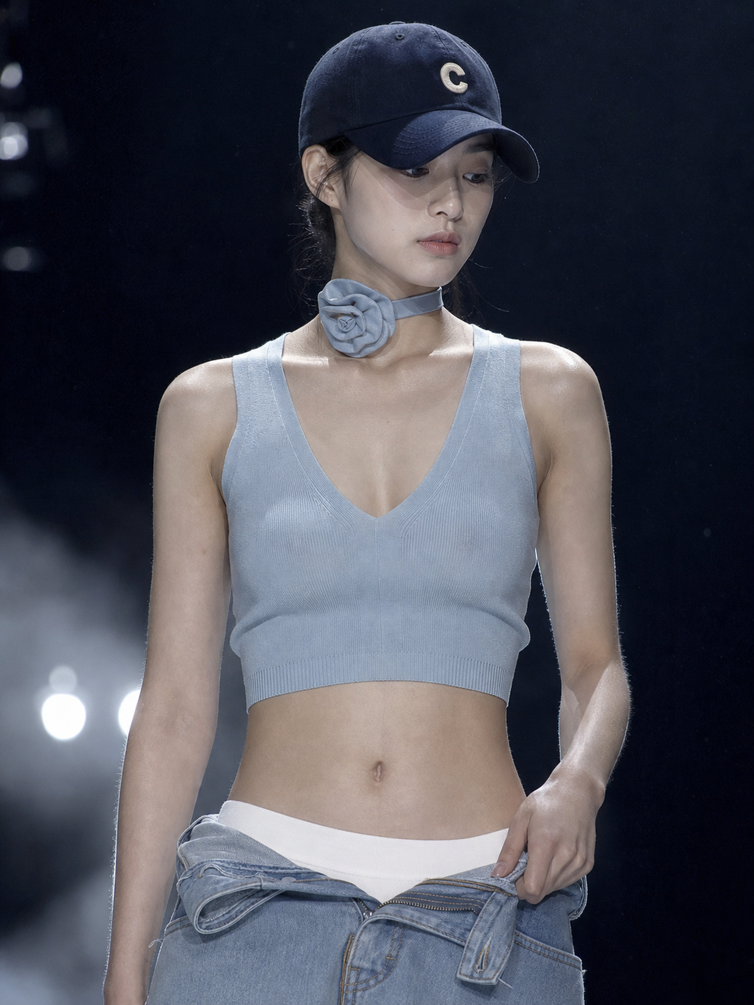 超写实高级时装秀人像摄影，一位20多岁的东亚年轻女性模特站在昏暗的大型T台或舞台