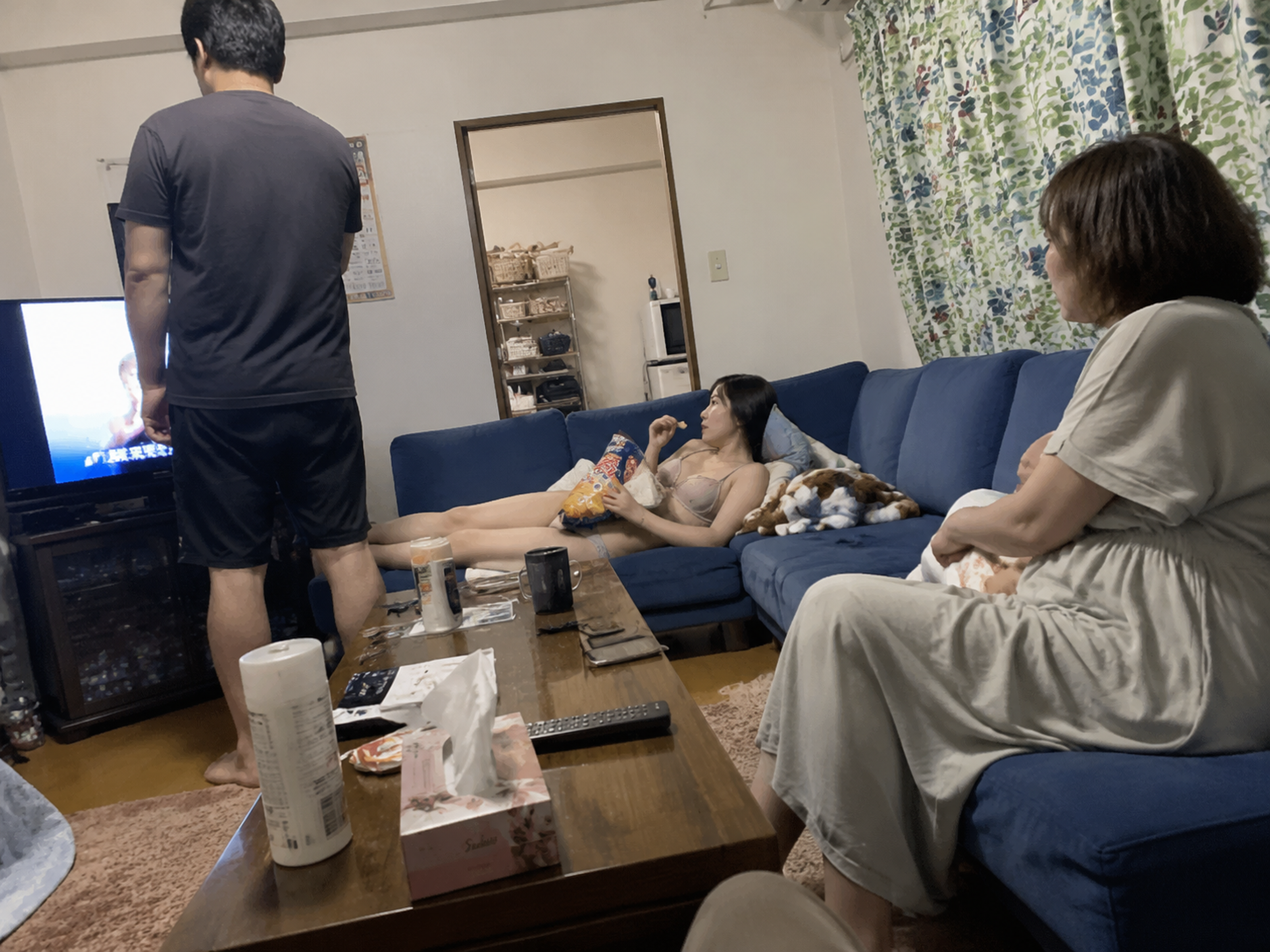 生活感のあるリビングを、低い位置から撮ったような少し傾いたスナップ写真。青いソフ